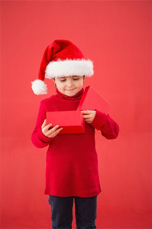 simsearch:400-07753751,k - Festive little boy opening a gift on red background Stock Photo - Budget Royalty-Free & Subscription, Code: 400-07902228