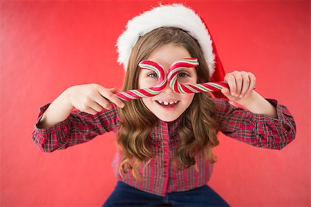 simsearch:400-07902186,k - Happy little girl in santa hat holding candy canes on red background Foto de stock - Super Valor sin royalties y Suscripción, Código: 400-07902234