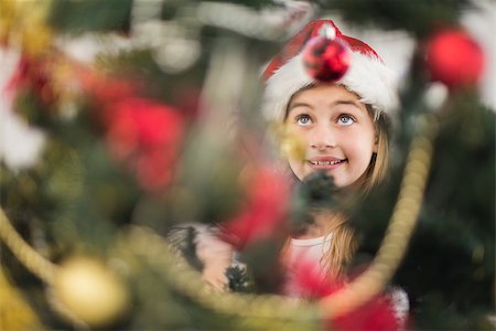 Festive litte girl decorating christmas tree at home in the living room Stock Photo - Budget Royalty-Free & Subscription, Code: 400-07902347