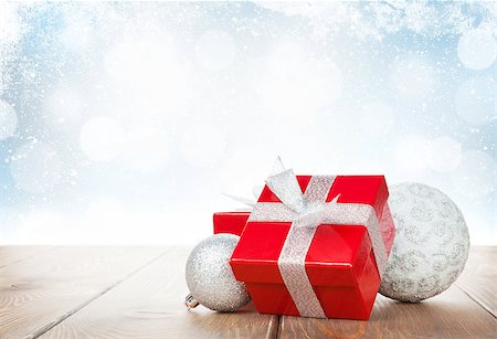 simsearch:400-07933751,k - Christmas gift box and baubles on wooden table with snow bokeh background for copy space Photographie de stock - Aubaine LD & Abonnement, Code: 400-07915315