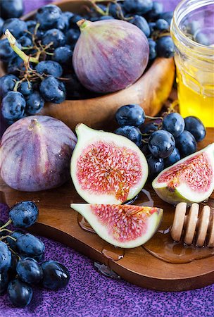 Fresh figs and dark grape with honey on table Stockbilder - Microstock & Abonnement, Bildnummer: 400-07915767