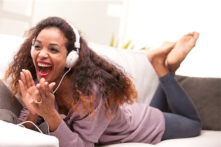 singing couch - african american woman singing on a sofa wearing white headphones Stock Photo - Budget Royalty-Free & Subscription, Code: 400-07916245