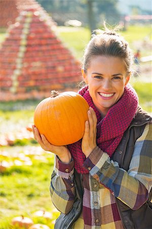 simsearch:400-07916492,k - Portrait of smiling young woman showing pumpkin Stock Photo - Budget Royalty-Free & Subscription, Code: 400-07916479