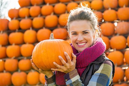 simsearch:400-07916492,k - Portrait of smiling young woman holding pumpkin Stock Photo - Budget Royalty-Free & Subscription, Code: 400-07916496
