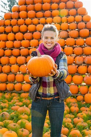 simsearch:400-07916492,k - Portrait of smiling young woman holding pumpkin Stock Photo - Budget Royalty-Free & Subscription, Code: 400-07916499