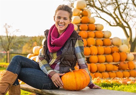 simsearch:400-07916492,k - Portrait of happy young woman sitting with pumpkin in front of pumpkin piramide Stock Photo - Budget Royalty-Free & Subscription, Code: 400-07916510