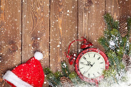 Christmas wooden background with clock, santa hat, snow fir tree and copy space Stock Photo - Budget Royalty-Free & Subscription, Code: 400-07917438