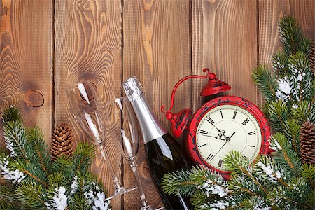 Christmas wooden background with clock, champagne, snow fir tree and copy space Foto de stock - Super Valor sin royalties y Suscripción, Código: 400-07917439