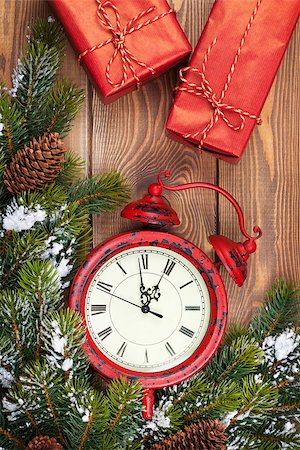 Christmas clock, gift boxes and snow fir tree over wooden background Foto de stock - Super Valor sin royalties y Suscripción, Código: 400-07917441