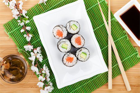 Sushi maki set, green tea and sakura branch over bamboo table Stock Photo - Budget Royalty-Free & Subscription, Code: 400-07917451