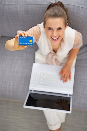 simsearch:400-06419734,k - Happy young woman with laptop showing credit card Stock Photo - Budget Royalty-Free & Subscription, Code: 400-07917968