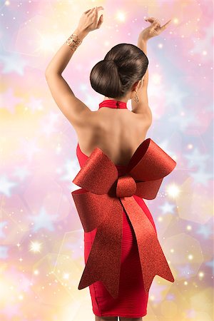 simsearch:400-04759494,k - sexy christmas woman with elegant glamour red dress and big bow posing turned on her naked back with golden jewellery Stock Photo - Budget Royalty-Free & Subscription, Code: 400-07918510