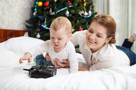 simsearch:400-09222788,k - Young Caucasian mother and toddler son playing with RC controller against decorated Christmas tree at home Photographie de stock - Aubaine LD & Abonnement, Code: 400-07919168