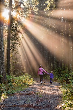 simsearch:400-09136205,k - Sun rays beating down on mother and daughter walking in forest Stockbilder - Microstock & Abonnement, Bildnummer: 400-07919397
