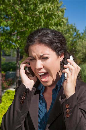 anger woman shouting with two mobiles in exterior Stock Photo - Budget Royalty-Free & Subscription, Code: 400-07919424