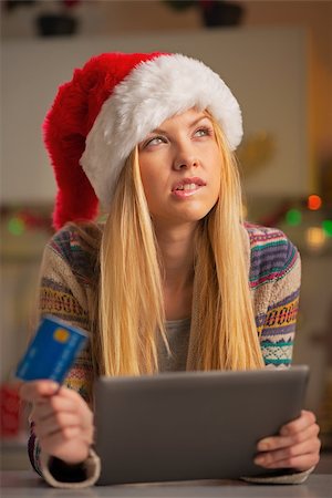 simsearch:400-06419734,k - Portrait of thoughtful teenager girl in santa hat with credit card using tablet pc Stock Photo - Budget Royalty-Free & Subscription, Code: 400-07924194