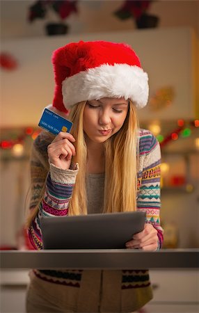 simsearch:400-06419734,k - Portrait of thoughtful teenager girl in santa hat with credit card using tablet pc Stock Photo - Budget Royalty-Free & Subscription, Code: 400-07924192