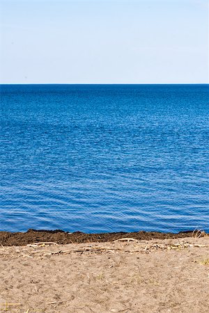 Part of beach on blue water against white sky. Fotografie stock - Microstock e Abbonamento, Codice: 400-07924489