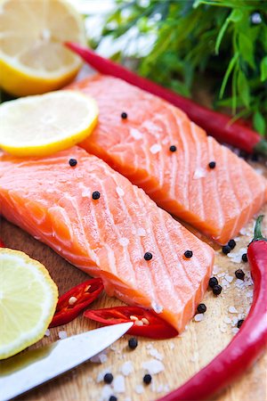 Raw salmon with lemon and pepper on cutting board Stock Photo - Budget Royalty-Free & Subscription, Code: 400-07924864