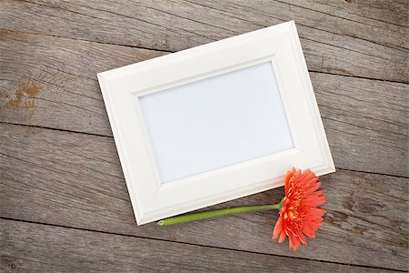 simsearch:400-07662543,k - Blank photo frame and orange gerbera on wooden table background Stock Photo - Budget Royalty-Free & Subscription, Code: 400-07925203