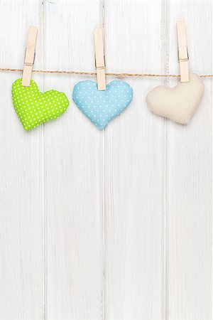 Valentines day toy hearts hanging on rope over white wooden background with copy space Stock Photo - Budget Royalty-Free & Subscription, Code: 400-07925325