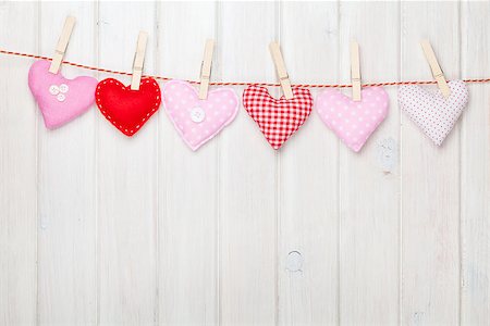 simsearch:400-07922855,k - Valentines day toy hearts hanging on rope over white wooden background with copy space Fotografie stock - Microstock e Abbonamento, Codice: 400-07925323