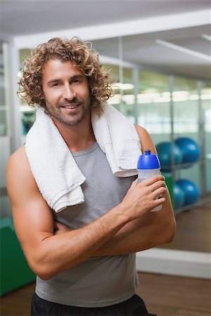 simsearch:400-07925663,k - Portrait of a smiling handsome young man holding water bottle at the gym Stockbilder - Microstock & Abonnement, Bildnummer: 400-07925664