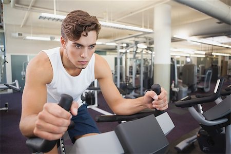 simsearch:400-07725687,k - Fit man working out on the exercise bike at the gym Photographie de stock - Aubaine LD & Abonnement, Code: 400-07925976