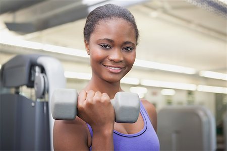 simsearch:400-07777565,k - Fit woman smiling at camera holding dumbbell at the gym Stockbilder - Microstock & Abonnement, Bildnummer: 400-07926031