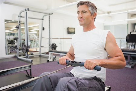 simsearch:400-07936740,k - Fit man working out on rowing machine at the gym Foto de stock - Super Valor sin royalties y Suscripción, Código: 400-07926050