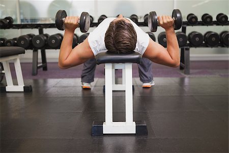 simsearch:400-08017390,k - Fit man lifting dumbbells lying on the bench at the gym Photographie de stock - Aubaine LD & Abonnement, Code: 400-07926066