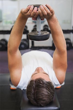 simsearch:400-08017390,k - Fit man lifting dumbbell lying on the bench at the gym Photographie de stock - Aubaine LD & Abonnement, Code: 400-07926067