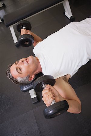 simsearch:400-08017390,k - Fit man lifting dumbbells lying on the bench at the gym Photographie de stock - Aubaine LD & Abonnement, Code: 400-07926069