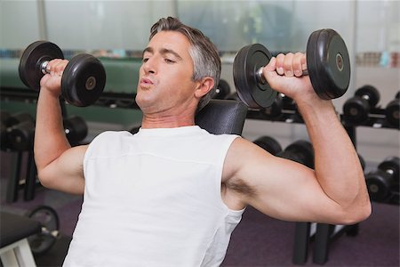 simsearch:400-08017390,k - Fit man lifting dumbbells lying on the bench at the gym Photographie de stock - Aubaine LD & Abonnement, Code: 400-07926072