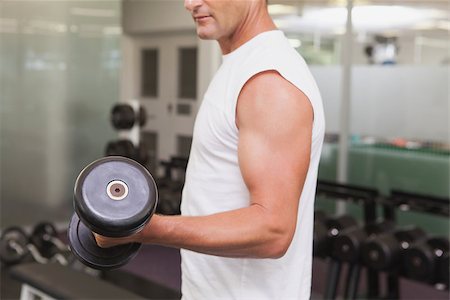 simsearch:400-08017390,k - Fit man lifting heavy black dumbbell at the gym Photographie de stock - Aubaine LD & Abonnement, Code: 400-07926073