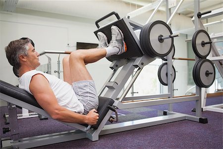 simsearch:400-08017390,k - Fit man using weights machine for legs at the gym Photographie de stock - Aubaine LD & Abonnement, Code: 400-07926098