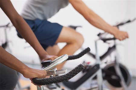 simsearch:400-07725687,k - Fit people working out on the exercise bikes at the gym Photographie de stock - Aubaine LD & Abonnement, Code: 400-07926131