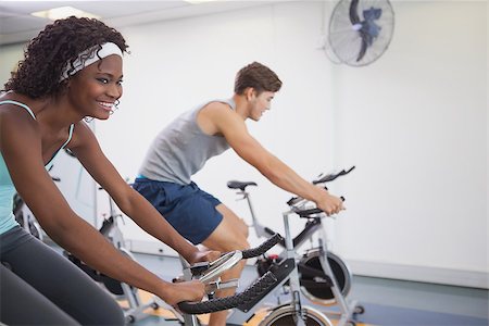 simsearch:400-07725687,k - Fit people working out on the exercise bikes at the gym Photographie de stock - Aubaine LD & Abonnement, Code: 400-07926132