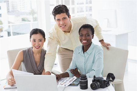 simsearch:400-07926810,k - Casual business team looking at laptop together in creative office Fotografie stock - Microstock e Abbonamento, Codice: 400-07926209