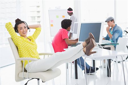 Young creative woman sitting with feet up in creative office Stock Photo - Budget Royalty-Free & Subscription, Code: 400-07926454