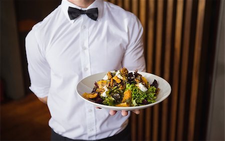 simsearch:400-05230474,k - Waiter showing plate of salad to camera in a bar Stock Photo - Budget Royalty-Free & Subscription, Code: 400-07926559