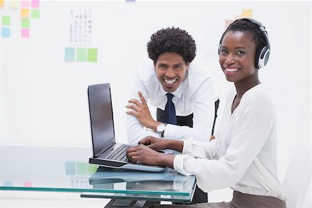 simsearch:400-07926750,k - Smiling business coworkers using laptop in the office Stock Photo - Budget Royalty-Free & Subscription, Code: 400-07926740