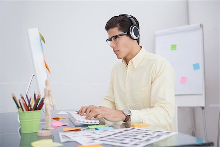 simsearch:400-07926810,k - Serious designer listening music and working in his office Fotografie stock - Microstock e Abbonamento, Codice: 400-07926808