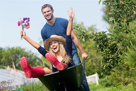 simsearch:400-08116305,k - Man pushing his girlfriend in a wheelbarrow at home in the garden Stock Photo - Budget Royalty-Free & Subscription, Code: 400-07927044