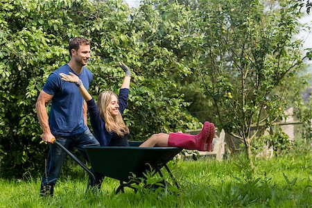 simsearch:400-07927044,k - Man pushing his girlfriend in a wheelbarrow at home in the garden Stock Photo - Budget Royalty-Free & Subscription, Code: 400-07927049