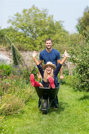 simsearch:400-07927044,k - Man pushing his girlfriend in a wheelbarrow at home in the garden Stock Photo - Budget Royalty-Free & Subscription, Code: 400-07927041