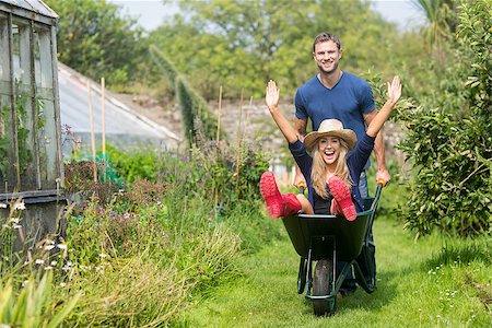 simsearch:400-07927044,k - Man pushing his girlfriend in a wheelbarrow at home in the garden Stock Photo - Budget Royalty-Free & Subscription, Code: 400-07927042
