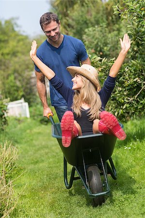 simsearch:400-08116305,k - Man pushing his girlfriend in a wheelbarrow at home in the garden Stock Photo - Budget Royalty-Free & Subscription, Code: 400-07927043