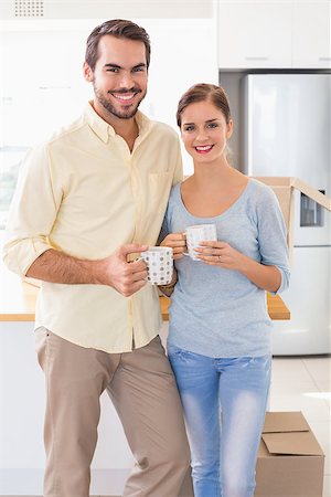 simsearch:400-07928013,k - Young couple smiling at the camera in their new home Fotografie stock - Microstock e Abbonamento, Codice: 400-07927123