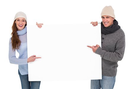 Casual couple in warm clothing holding poster on white background Stockbilder - Microstock & Abonnement, Bildnummer: 400-07927774